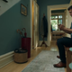 A man plays Nintendo Switch in his hallway.